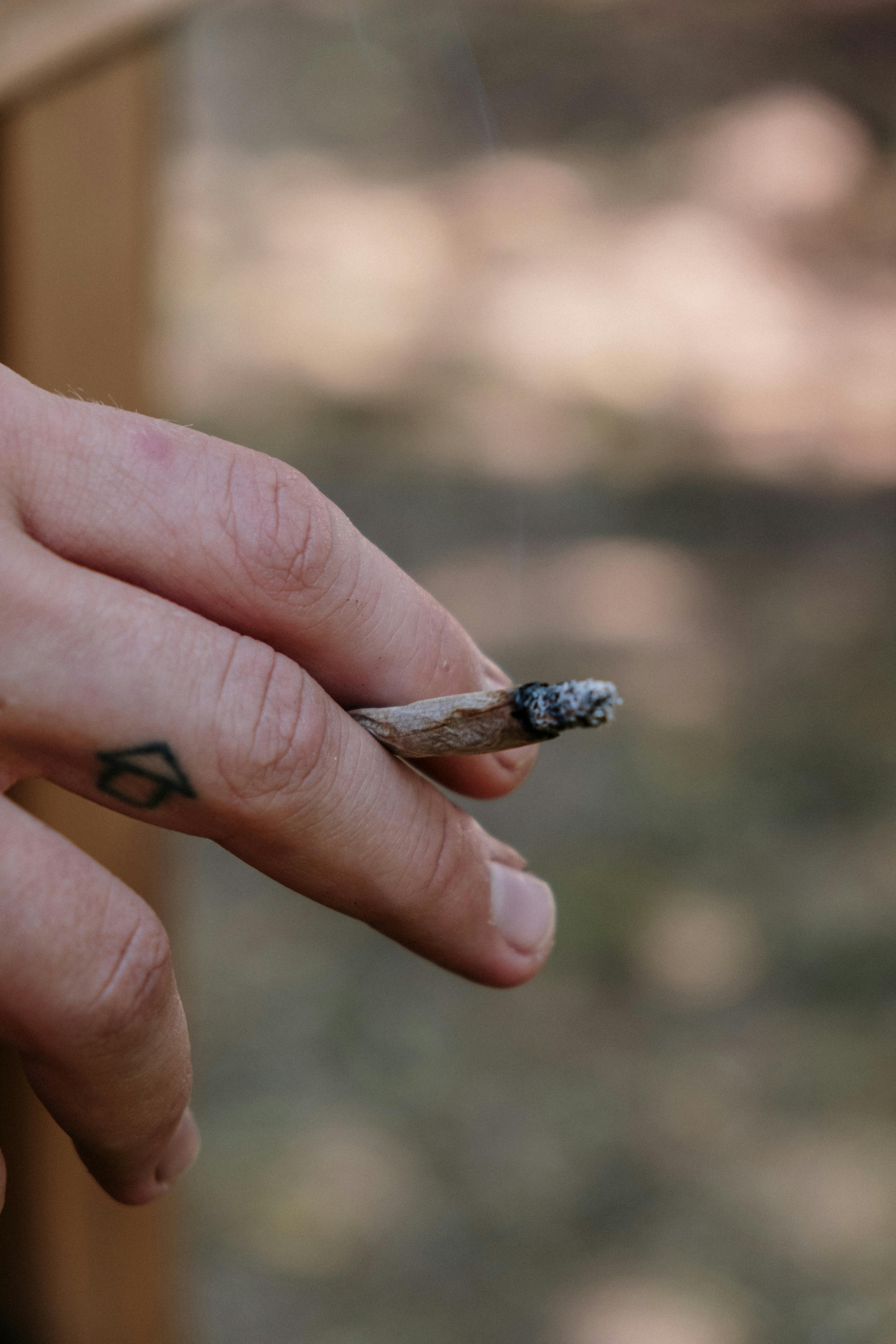 Brennender Joint in einer Hand